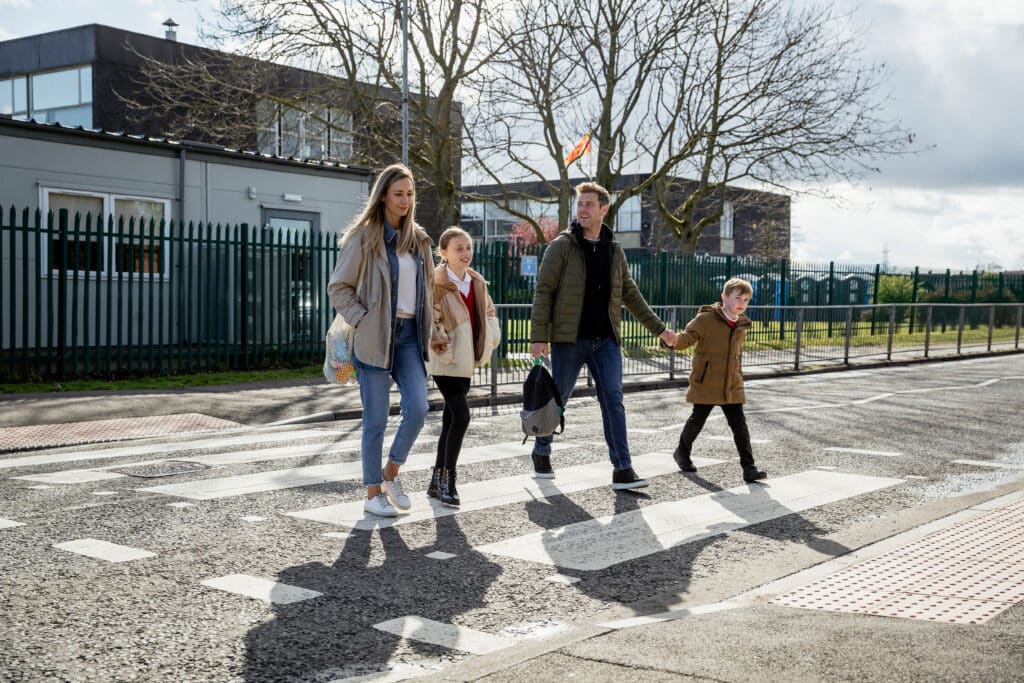 A,Shot,Of,A,Four,Person,Family,Crossing,The,Road